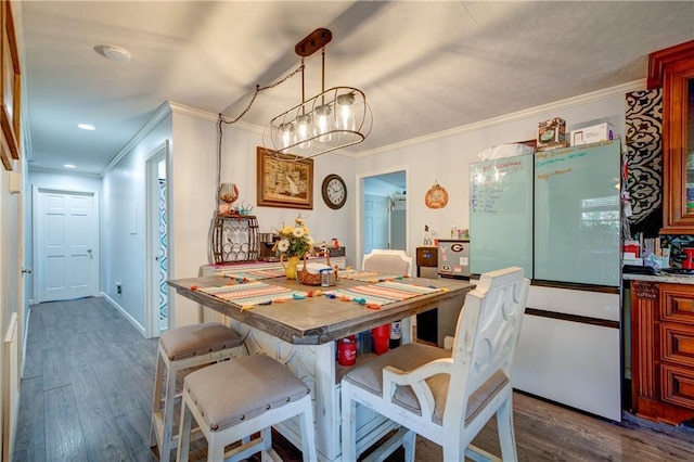 dining space featuring baseboards, dark wood-style flooring, and crown molding