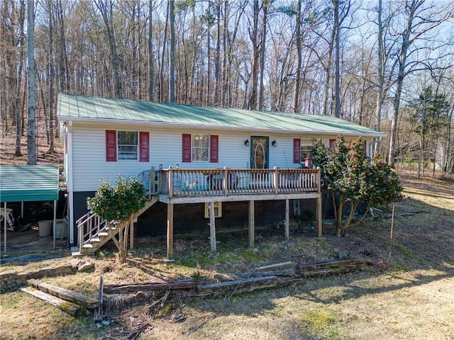 view of front of home with stairway, metal roof, and a deck