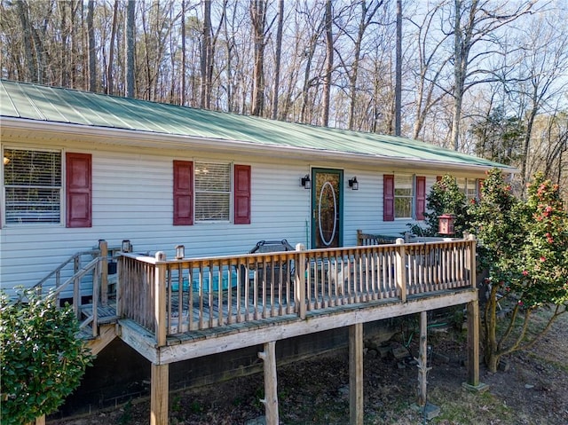 view of front facade featuring metal roof and a wooden deck