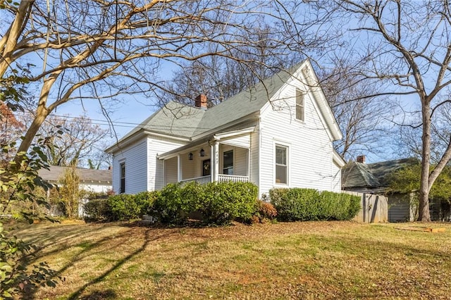 view of property exterior with a porch and a lawn