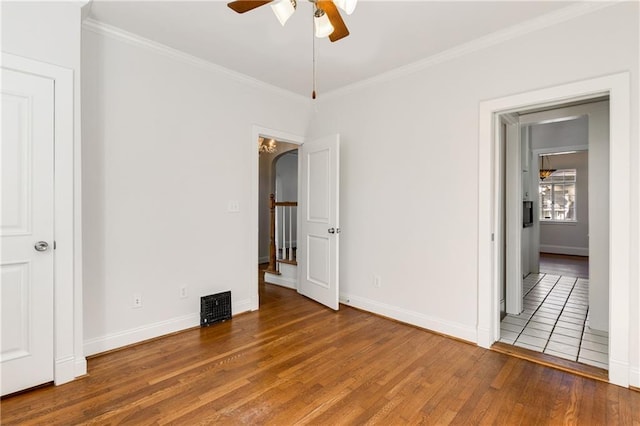 unfurnished bedroom featuring crown molding, hardwood / wood-style flooring, and ceiling fan