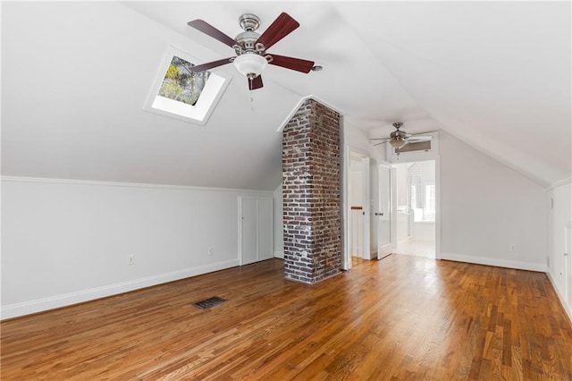 additional living space featuring wood-type flooring, lofted ceiling, and ceiling fan