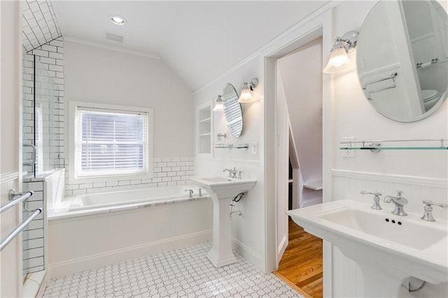 bathroom featuring a washtub, vaulted ceiling, ornamental molding, and toilet