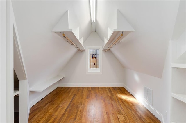 bonus room with hardwood / wood-style flooring and vaulted ceiling