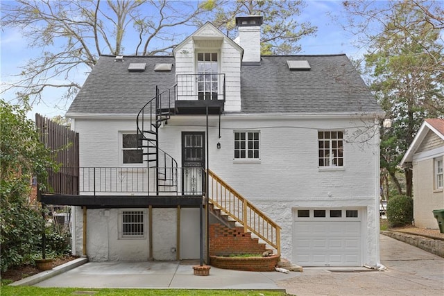 rear view of house featuring a garage and a patio area