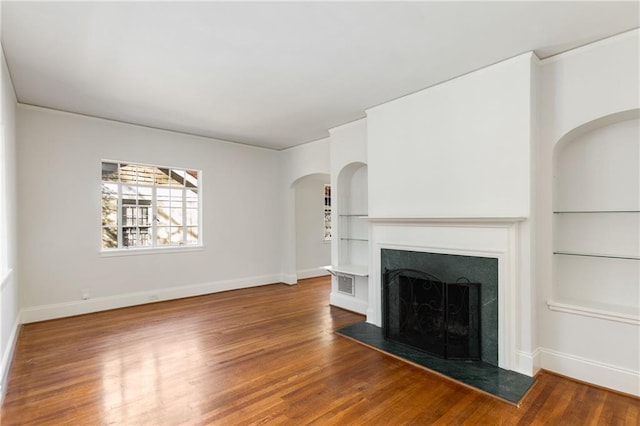 unfurnished living room with hardwood / wood-style flooring and built in features