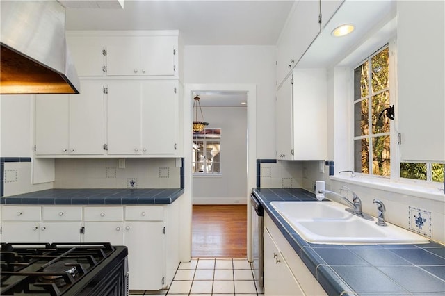 kitchen featuring exhaust hood, tile counters, and white cabinets