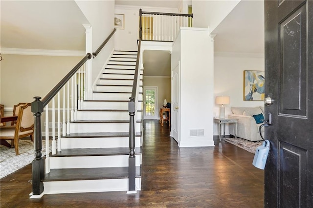 entryway featuring wood finished floors, visible vents, and crown molding