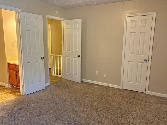 unfurnished bedroom featuring carpet flooring and a textured ceiling