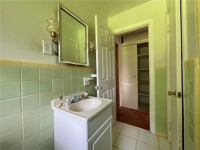 bathroom with vanity, tile patterned flooring, tile walls, and a wainscoted wall