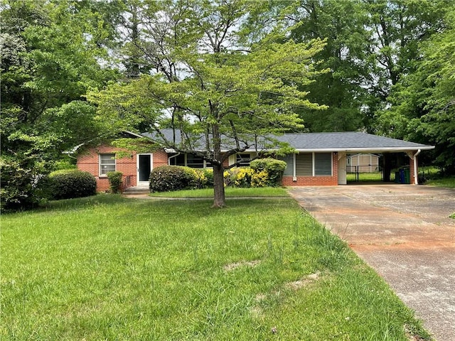 ranch-style home with brick siding, driveway, a front yard, and a carport