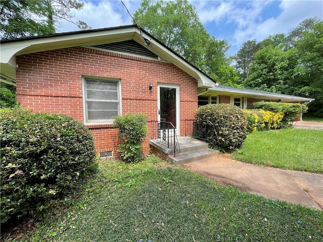 view of front of home featuring brick siding and a front lawn
