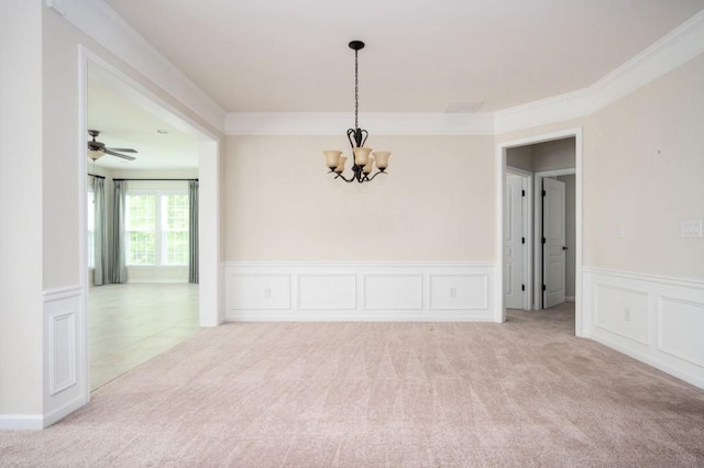 spare room featuring crown molding, wainscoting, carpet floors, an inviting chandelier, and a decorative wall