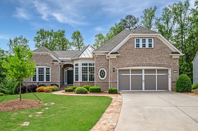 view of front of house with brick siding, a front lawn, roof with shingles, and concrete driveway