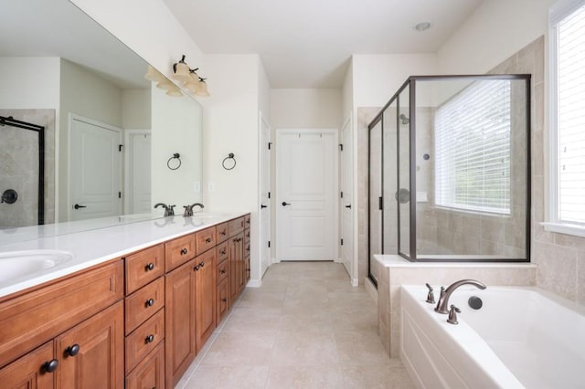 bathroom with double vanity, plenty of natural light, a bath, and a stall shower
