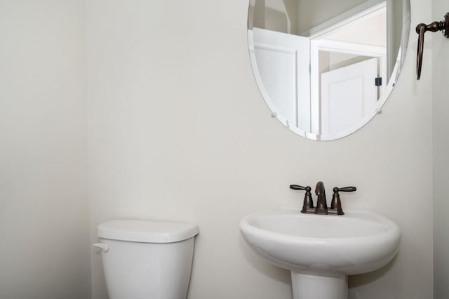half bathroom featuring a sink and toilet