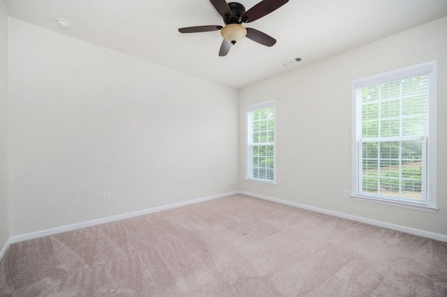 spare room with carpet floors, a ceiling fan, baseboards, and visible vents