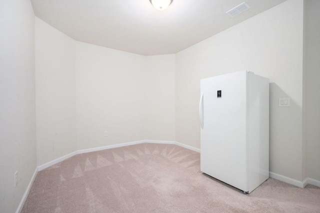 carpeted spare room featuring baseboards and visible vents