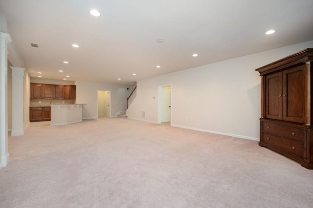 unfurnished living room featuring recessed lighting, baseboards, and stairway