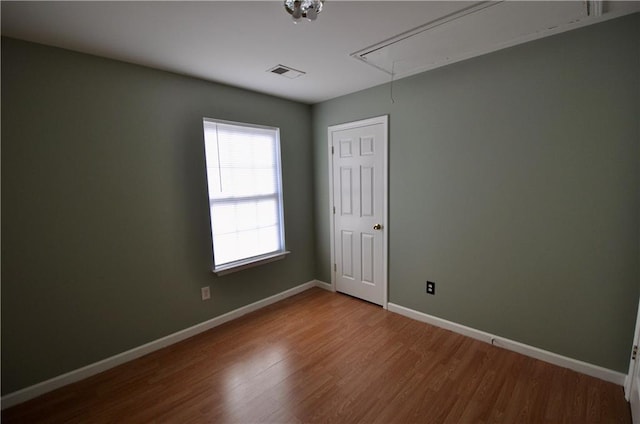 spare room featuring wood-type flooring