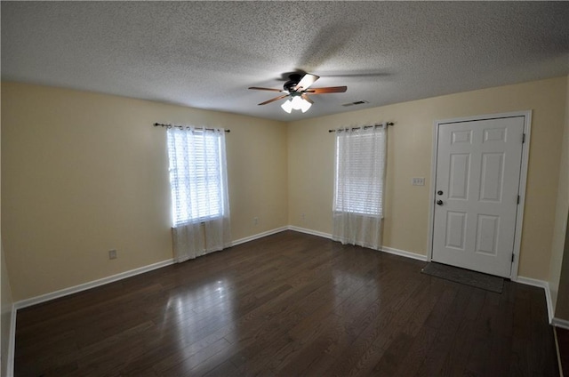 unfurnished room with ceiling fan, dark hardwood / wood-style flooring, and a textured ceiling