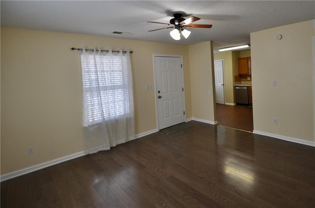 unfurnished room with ceiling fan, dark wood-type flooring, and a textured ceiling