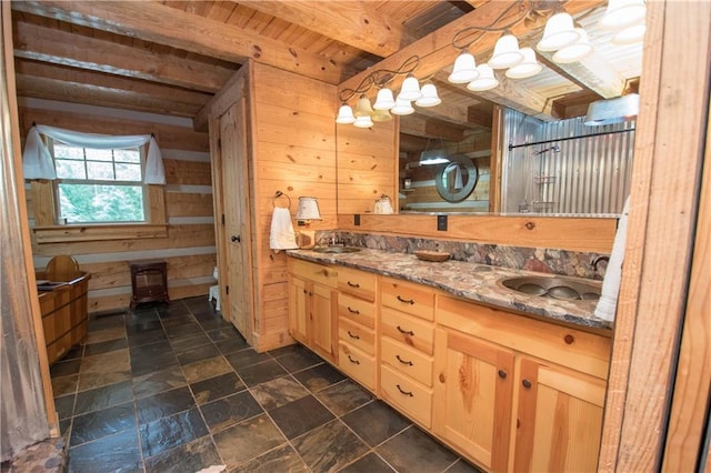 bathroom with tile flooring, wooden walls, beam ceiling, wood ceiling, and dual bowl vanity