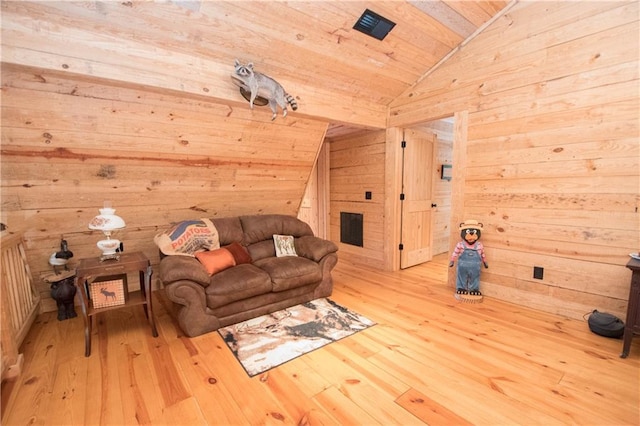 unfurnished living room with wooden walls, wood ceiling, vaulted ceiling, and light wood-type flooring