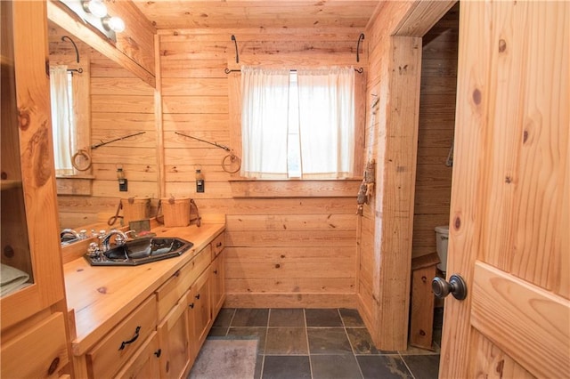 bathroom featuring wood walls, toilet, tile flooring, vanity, and wood ceiling