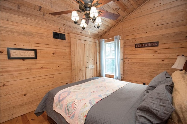 bedroom with wooden walls, ceiling fan, hardwood / wood-style floors, wood ceiling, and lofted ceiling