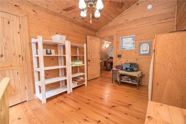 bedroom featuring light hardwood / wood-style floors, wooden ceiling, wooden walls, and vaulted ceiling