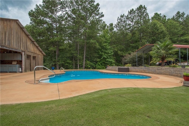 view of pool with a lawn and a patio