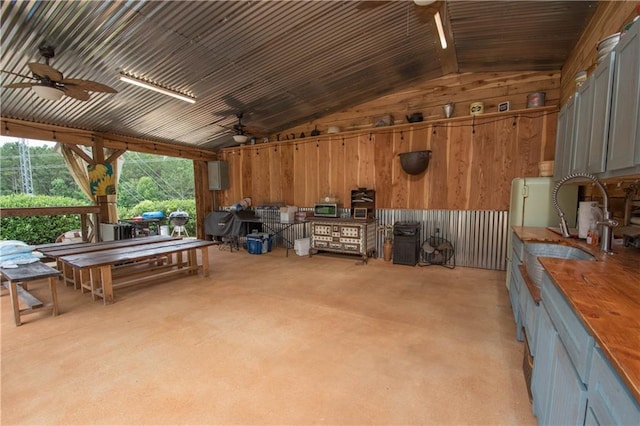 interior space with ceiling fan and wood walls