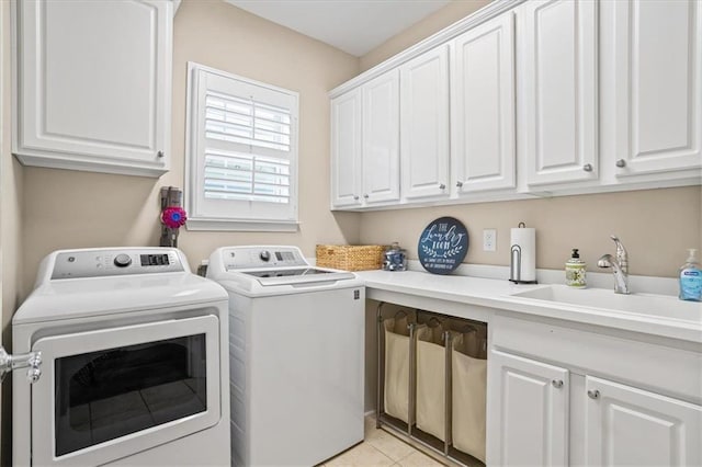 laundry room with washer and clothes dryer, cabinet space, and light tile patterned floors
