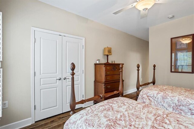 bedroom with dark wood-style floors, a closet, ceiling fan, and baseboards