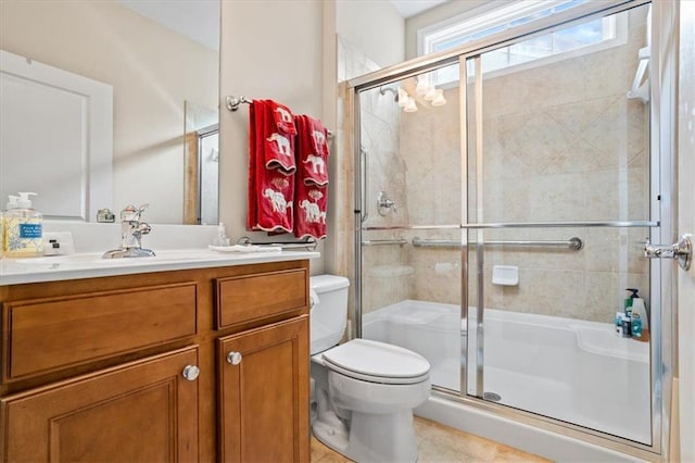bathroom with a stall shower, toilet, vanity, and tile patterned floors