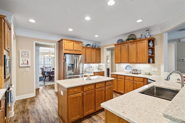 kitchen with stainless steel appliances, a sink, ornamental molding, open shelves, and a chandelier