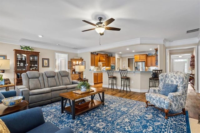living room featuring ceiling fan, crown molding, wood finished floors, and recessed lighting
