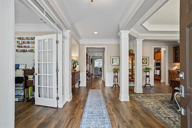 entryway with decorative columns, dark wood finished floors, ornamental molding, a wainscoted wall, and recessed lighting