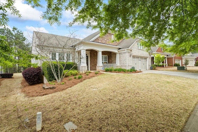 craftsman house with covered porch, driveway, brick siding, and a front yard