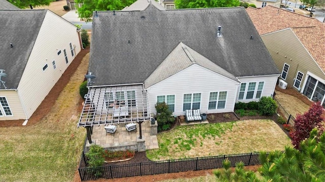 rear view of house with a patio area and a shingled roof