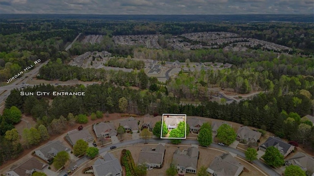 aerial view of property's location with a forest, property parcel outlined, and nearby suburban area