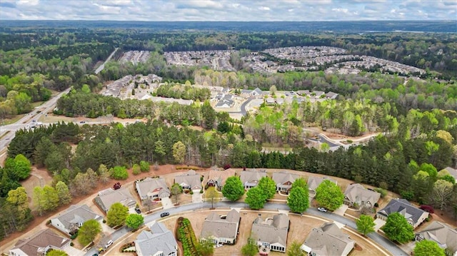 view of property location with a forest and nearby suburban area