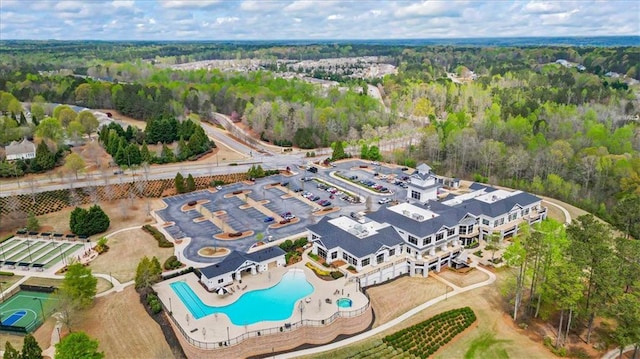 aerial view of a pool and a heavily wooded area