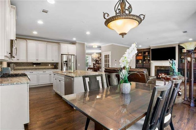 dining area featuring dark wood-type flooring, ornamental molding, and sink