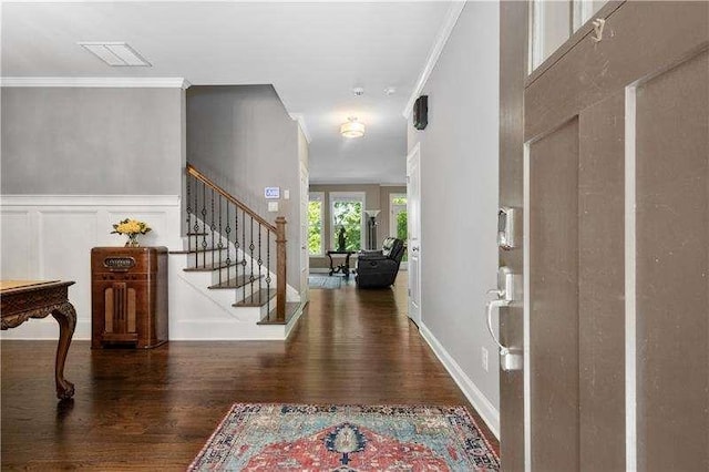 foyer featuring crown molding and dark wood-type flooring