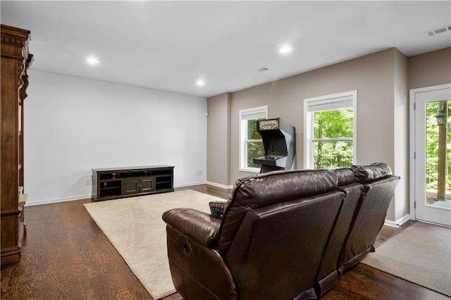 living room with a healthy amount of sunlight and dark wood-type flooring