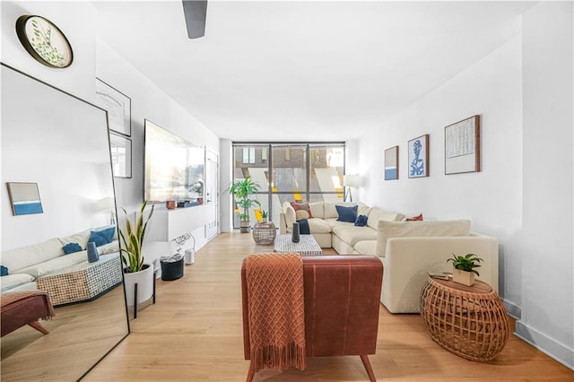 living room with floor to ceiling windows and light hardwood / wood-style flooring