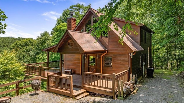 rear view of property featuring a wooden deck and a chimney