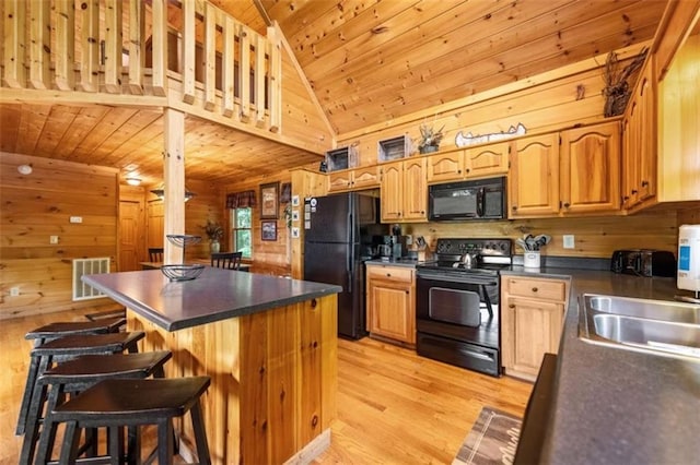 kitchen with wood ceiling, black appliances, wood walls, and dark countertops